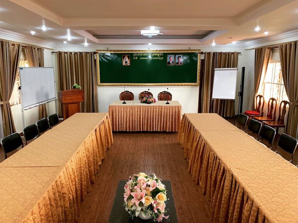 Meeting room set up with long tables and a presentation area